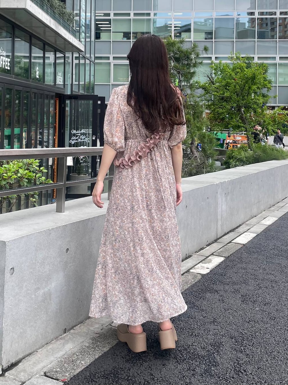 ベージュ系のサンダル、ピンク系のワンピース、ピンク系のスマホグッズを着用したレディースの夏コーディネートの2枚目の写真