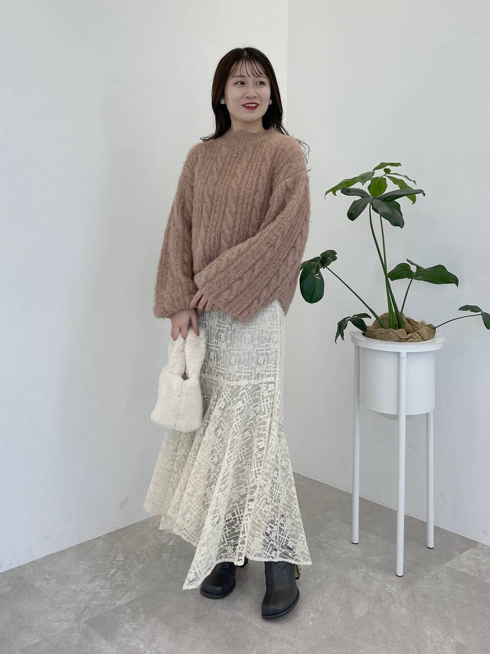 ホワイト系のチェスターコート、グレー系のブーツ、ホワイト系のスカートを着用したレディースの秋コーディネートの4枚目の写真