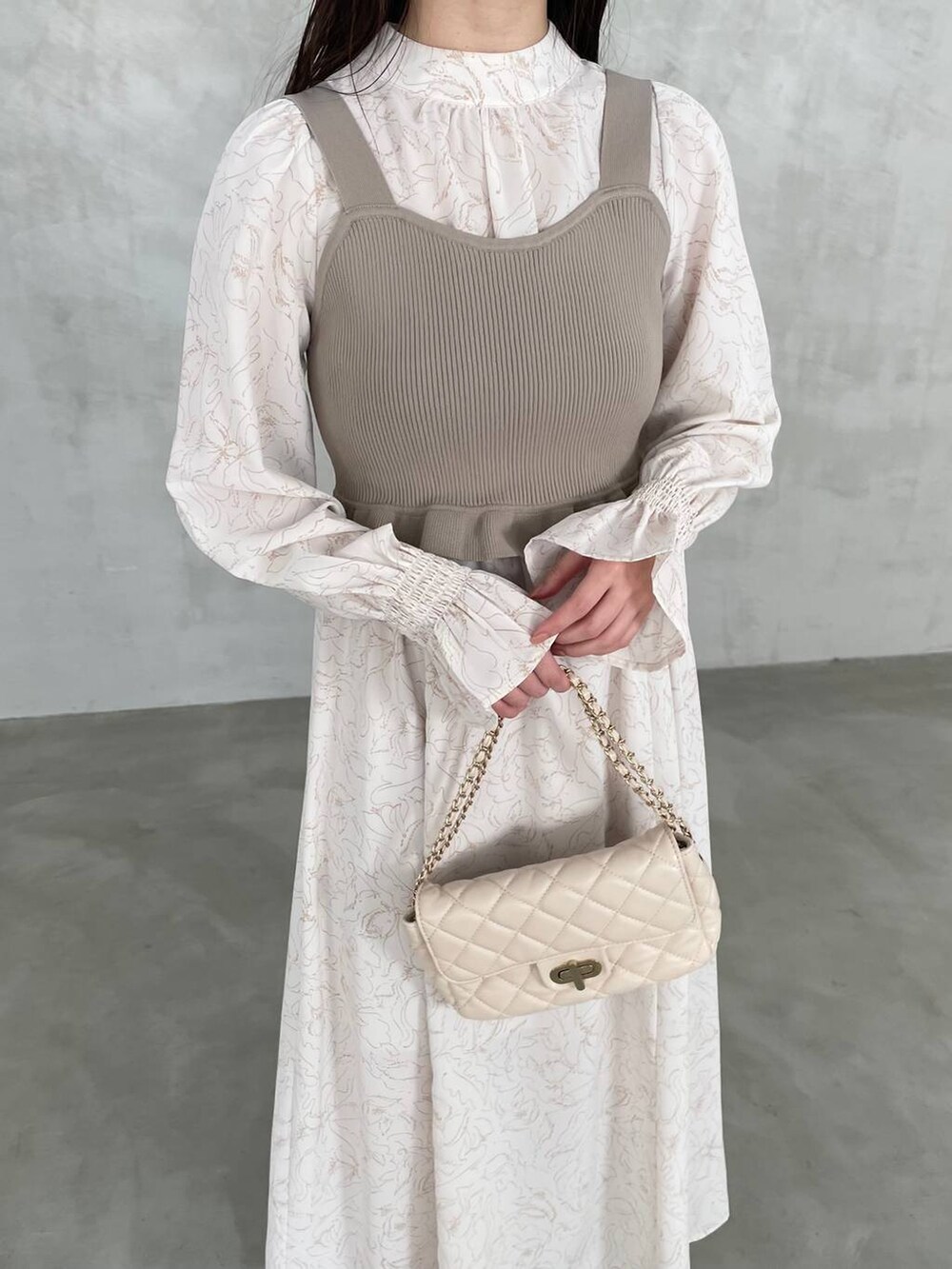 ホワイト系のショルダーバッグ、ベージュ系のワンピースを着用したレディースの冬コーディネートの4枚目の写真