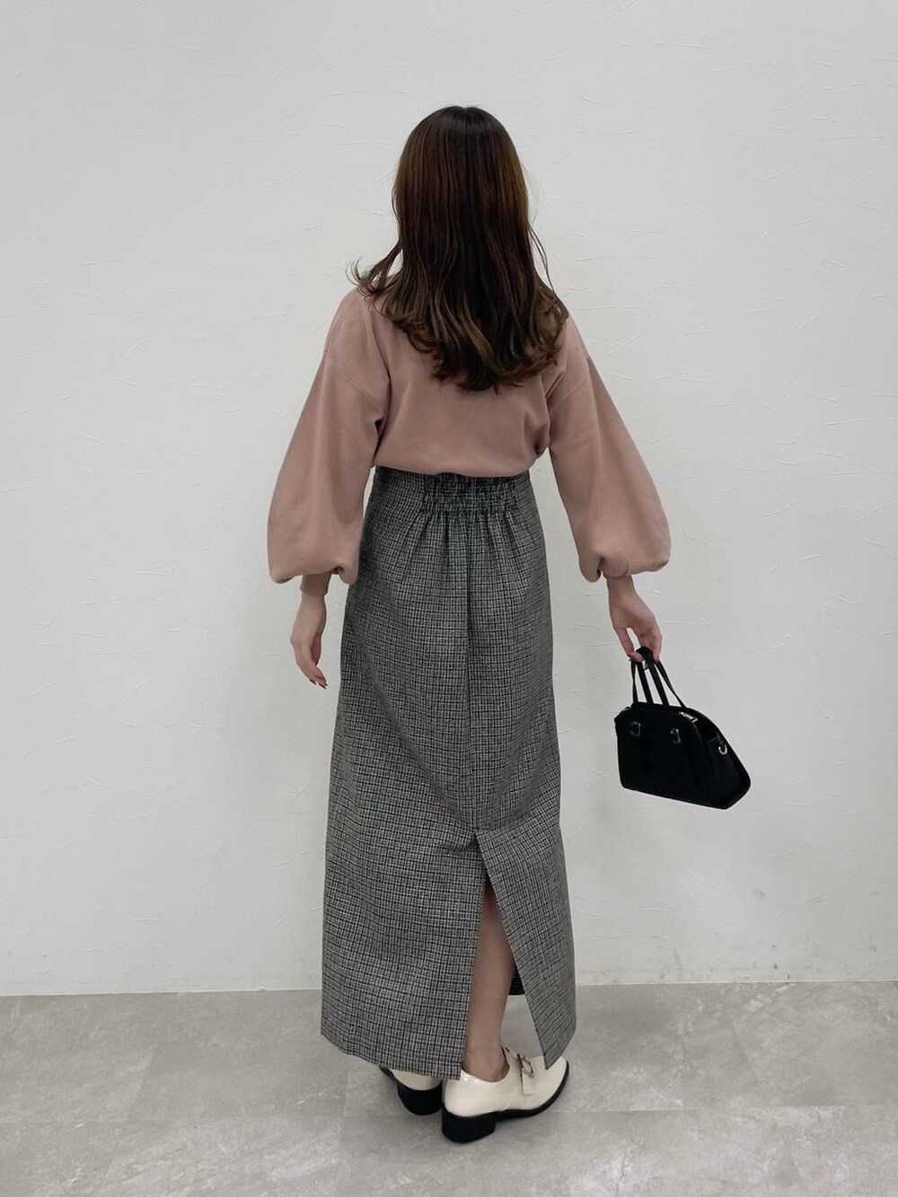 ブラック系のボストンバッグ、ホワイト系のその他シューズ、ピンク系のニット/セーターを着用したレディースの秋コーディネートの2枚目の写真