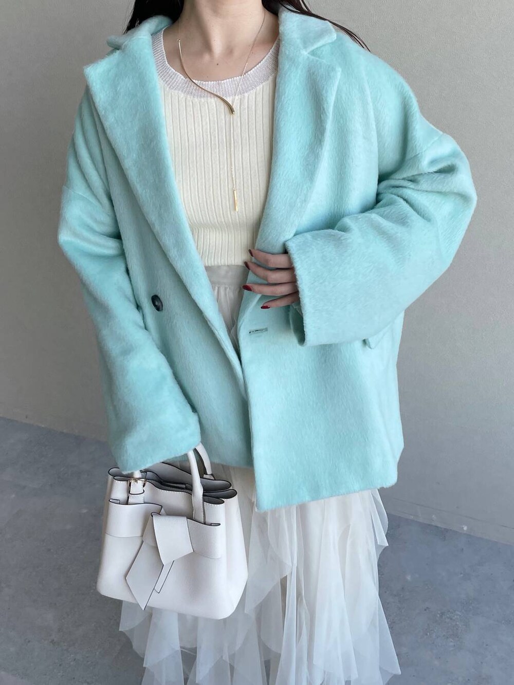 ホワイト系のブーツ、ホワイト系のショルダーバッグ、グリーン系のテーラードジャケットを着用したレディースの冬コーディネートの5枚目の写真