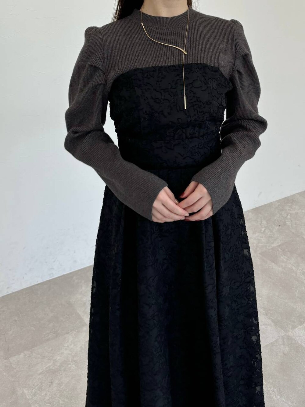 ブラック系のブーツ、ブラック系のショルダーバッグ、ブラック系のワンピースを着用したレディースの冬コーディネートの3枚目の写真