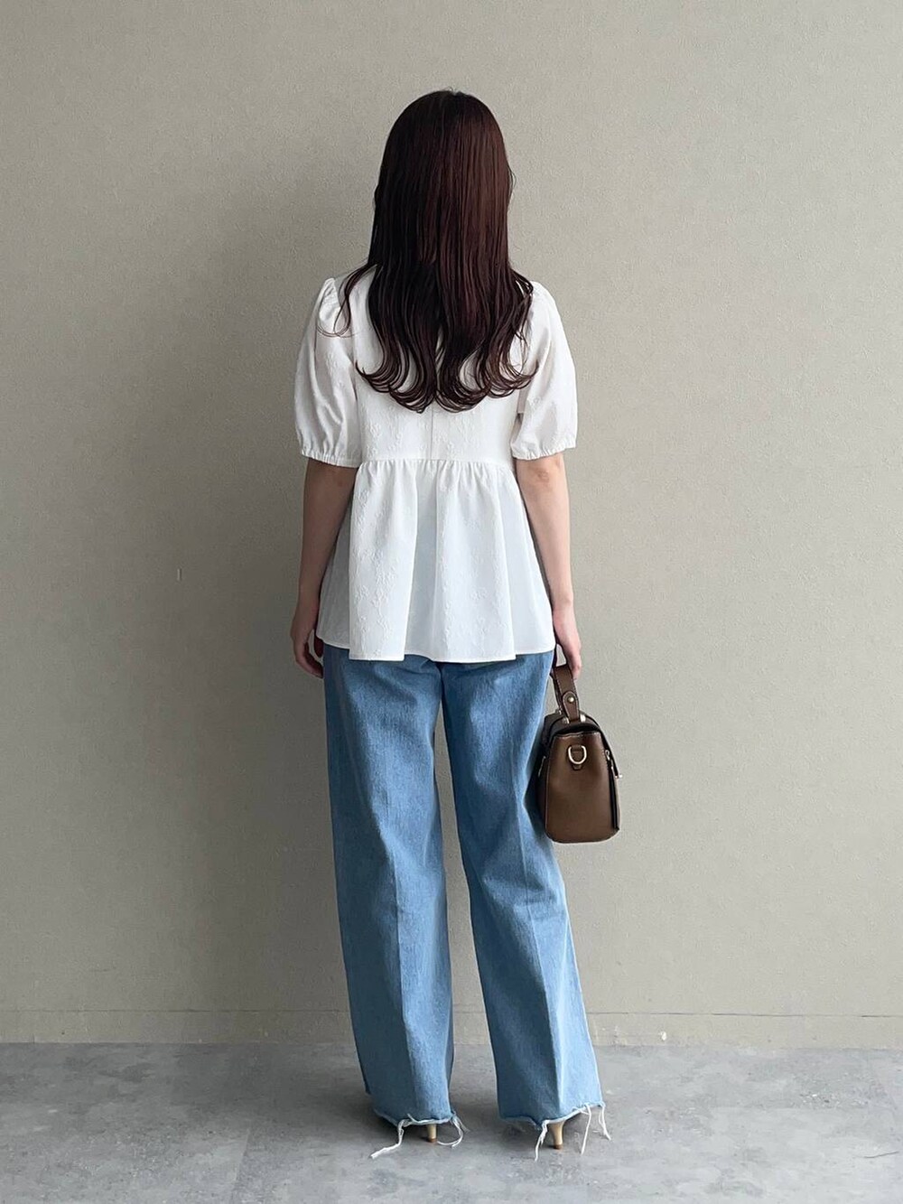 ゴールド系のパンプス、ブラウン系のショルダーバッグ、ホワイト系のシャツ/ブラウスを着用したレディースの夏コーディネートの2枚目の写真