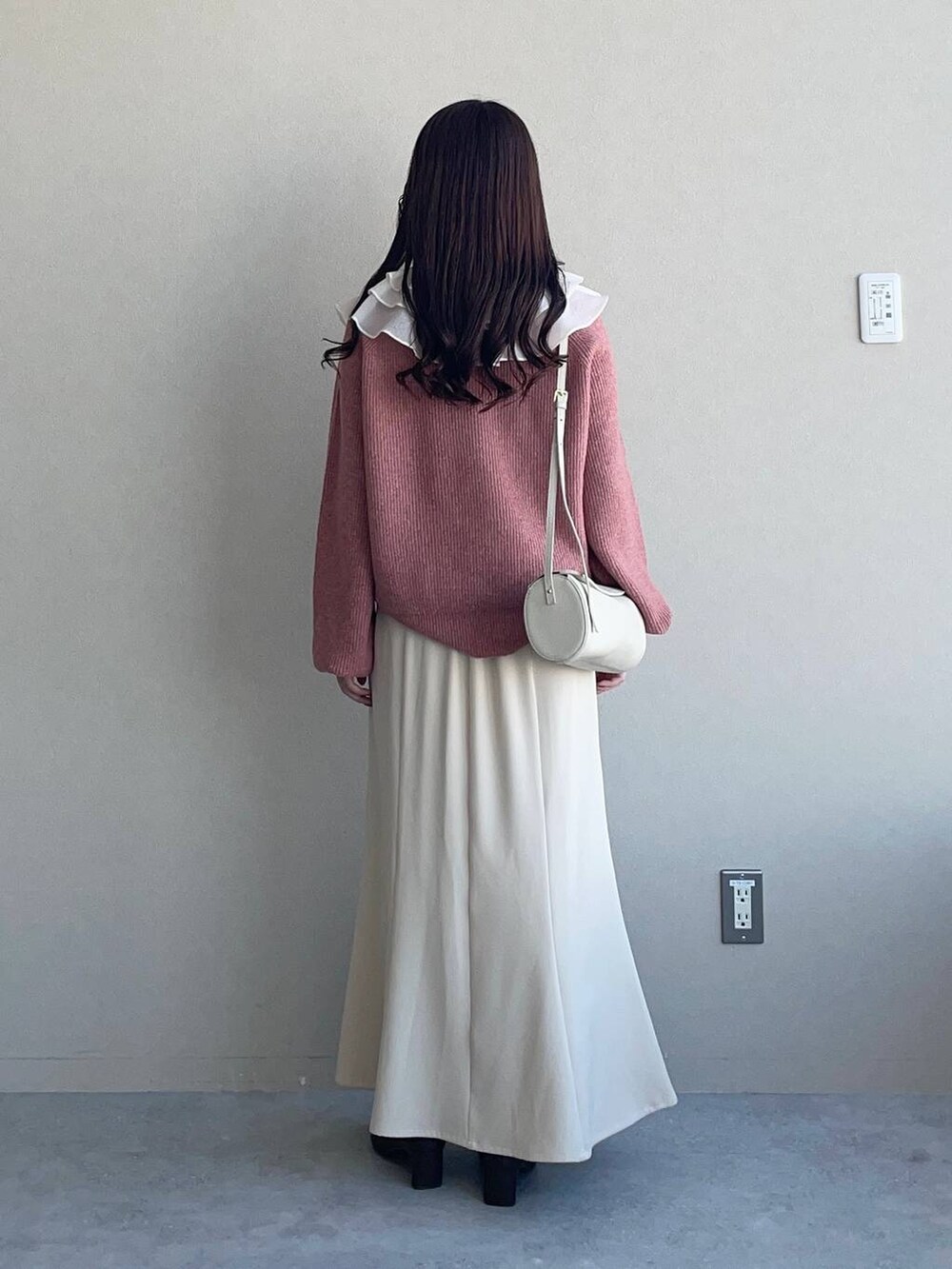 ベージュ系のスカート、ピンク系のニット/セーター、ホワイト系のシャツ/ブラウスを着用したレディースの秋コーディネートの2枚目の写真