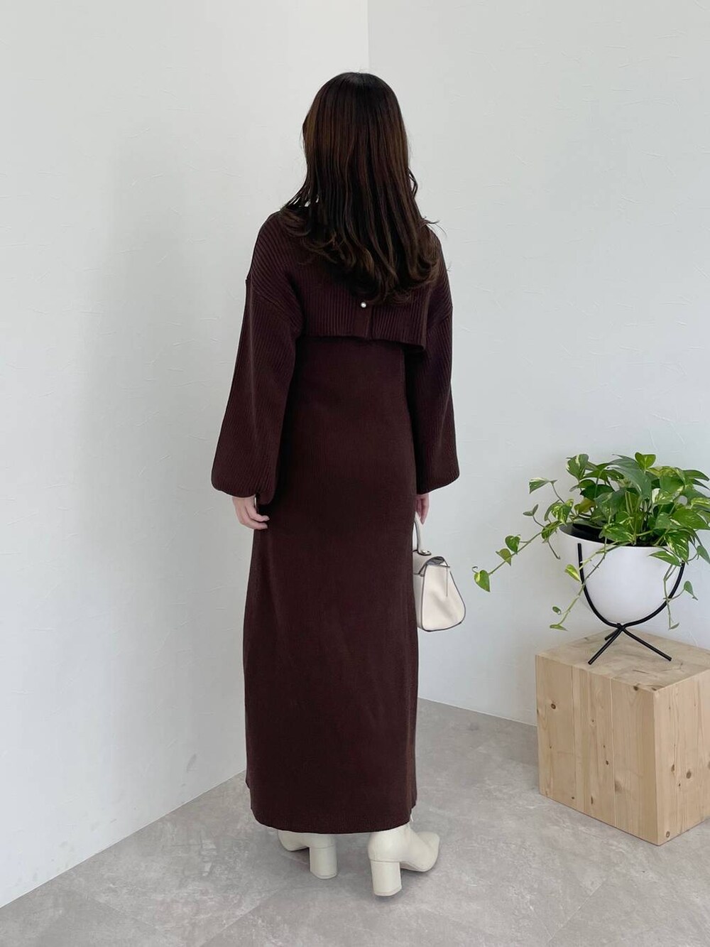 ホワイト系のその他アウター、ホワイト系のハンドバッグ、ホワイト系のブーツを着用したレディースの冬コーディネートの9枚目の写真