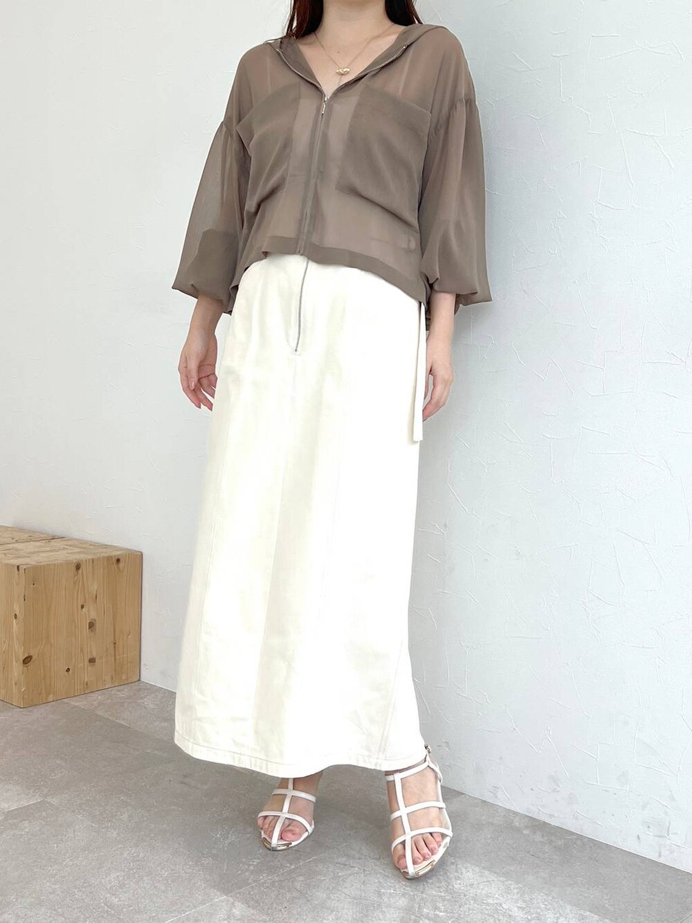 ホワイト系のスカート、ブラウン系のパーカー、ホワイト系のショルダーバッグを着用したレディースの夏コーディネートの4枚目の写真