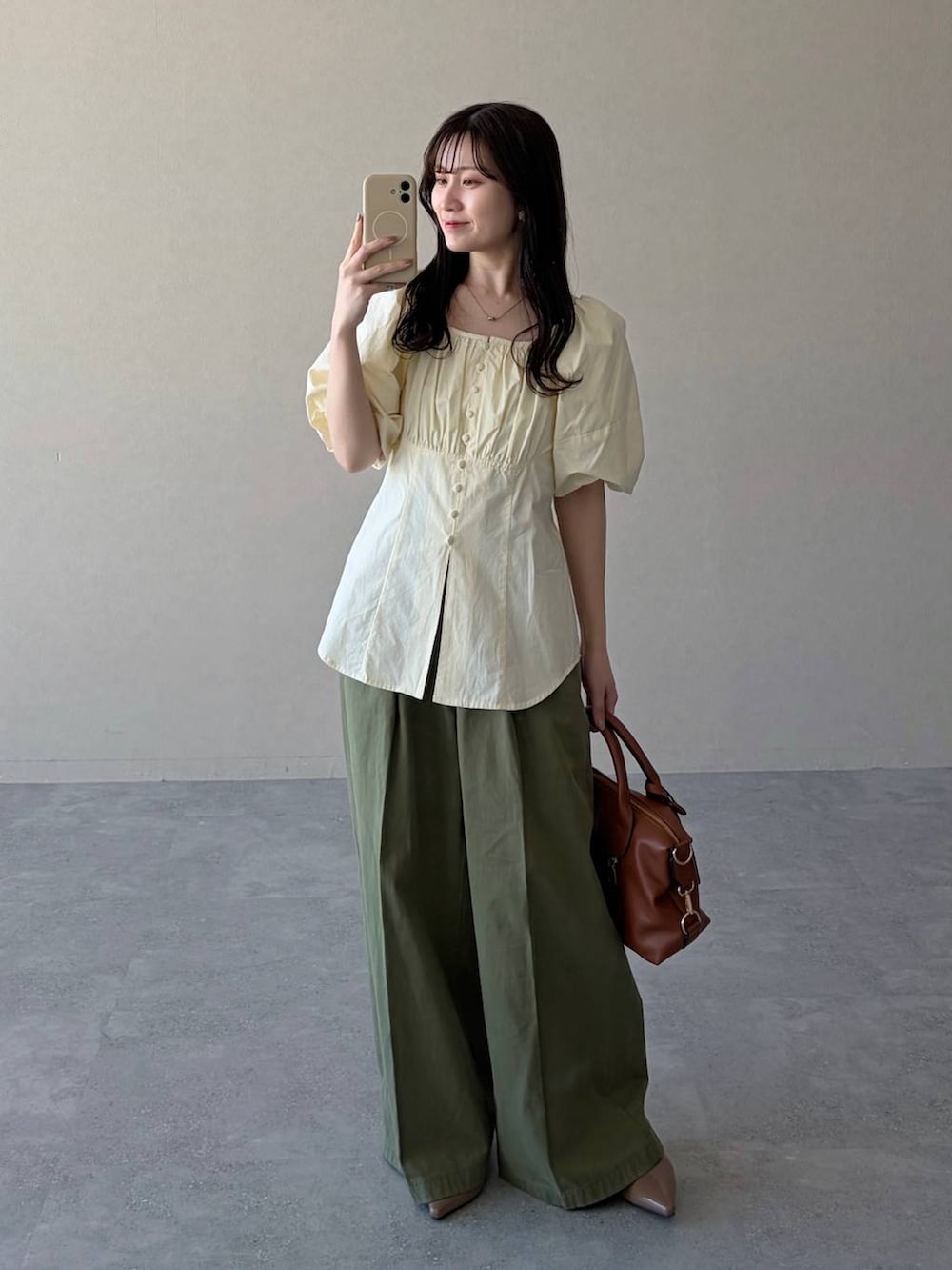 ブラウン系のボストンバッグ、ブラウン系のサンダル、ホワイト系のシャツ/ブラウスを着用したレディースの春コーディネートの4枚目の写真