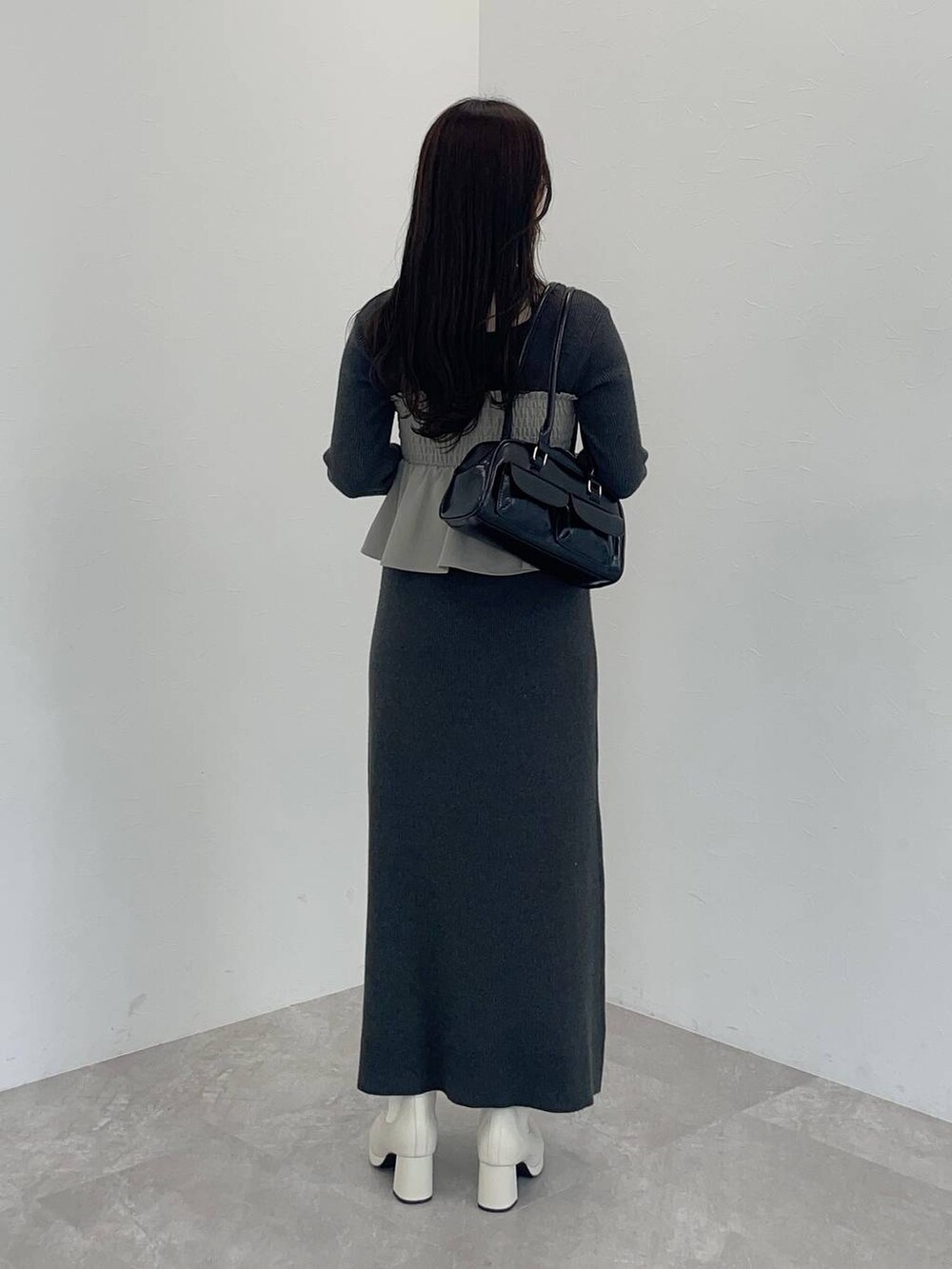 ホワイト系のブーツ、ベージュ系のその他パンツ、ブラック系のハンドバッグを着用したレディースの冬コーディネートの2枚目の写真