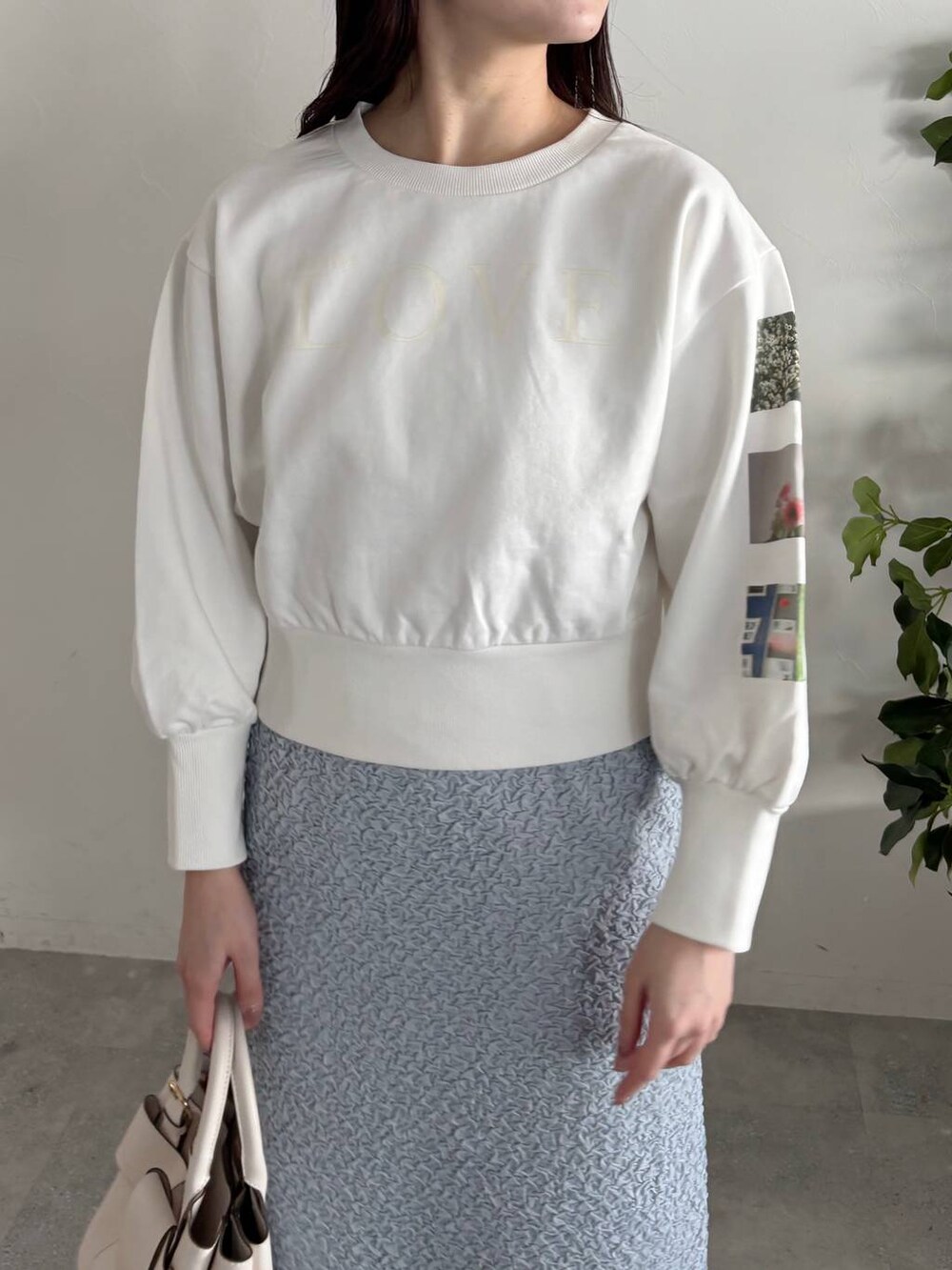 ホワイト系のショルダーバッグ、シルバー系のバレエシューズ、ブルー系のスカートを着用したレディースの春コーディネートの3枚目の写真