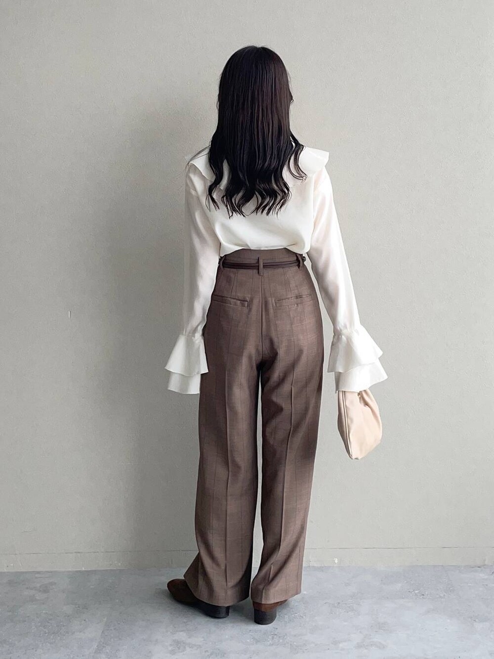 ベージュ系のハンドバッグ、ホワイト系のシャツ/ブラウス、ブラウン系のローファーを着用したレディースの秋コーディネートの2枚目の写真