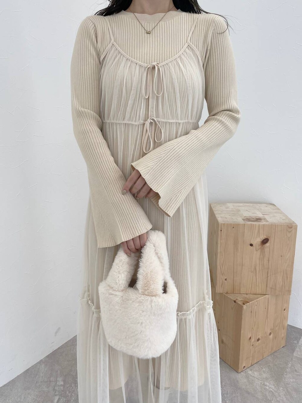 ホワイト系のブーツ、ホワイト系のハンドバッグ、ブラウン系のチェスターコートを着用したレディースの秋コーディネートの7枚目の写真