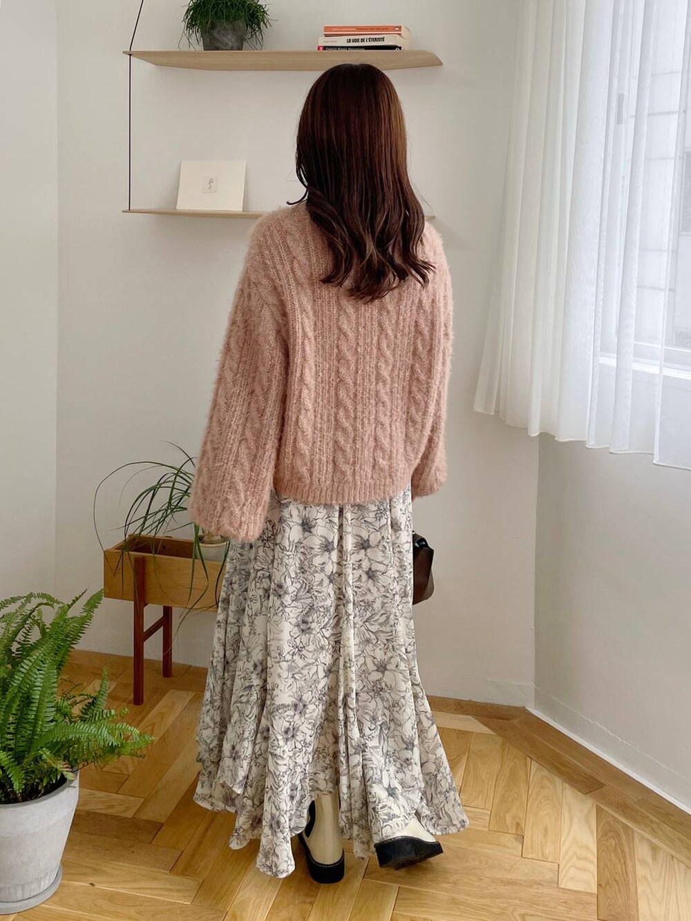 ブラック系のチェスターコート、ホワイト系のブーツ、ベージュ系のスカートを着用したレディースの秋コーディネートの5枚目の写真