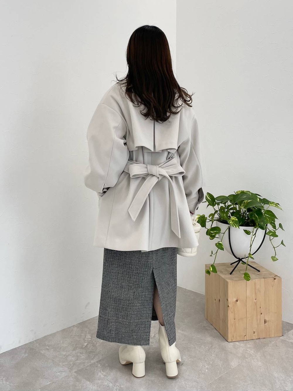 ホワイト系のチェスターコート、ホワイト系のブーツ、ピンク系のニット/セーターを着用したレディースの冬コーディネートの2枚目の写真