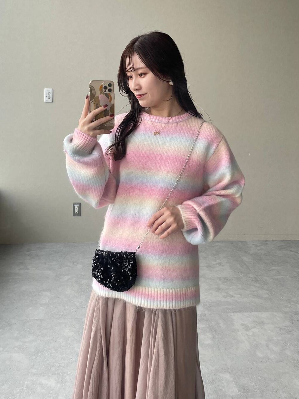 ホワイト系のブーツ、ベージュ系のスカート、ブラック系のショルダーバッグを着用したレディースの秋コーディネートの3枚目の写真