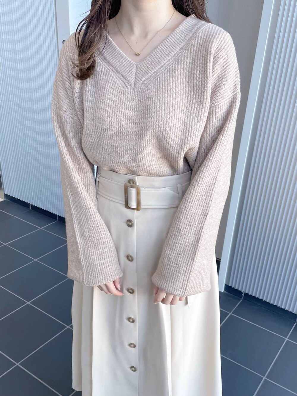 ベージュ系のニット/セーター、ホワイト系のブーツ、ベージュ系のジャンパースカートを着用したレディースの冬コーディネートの3枚目の写真