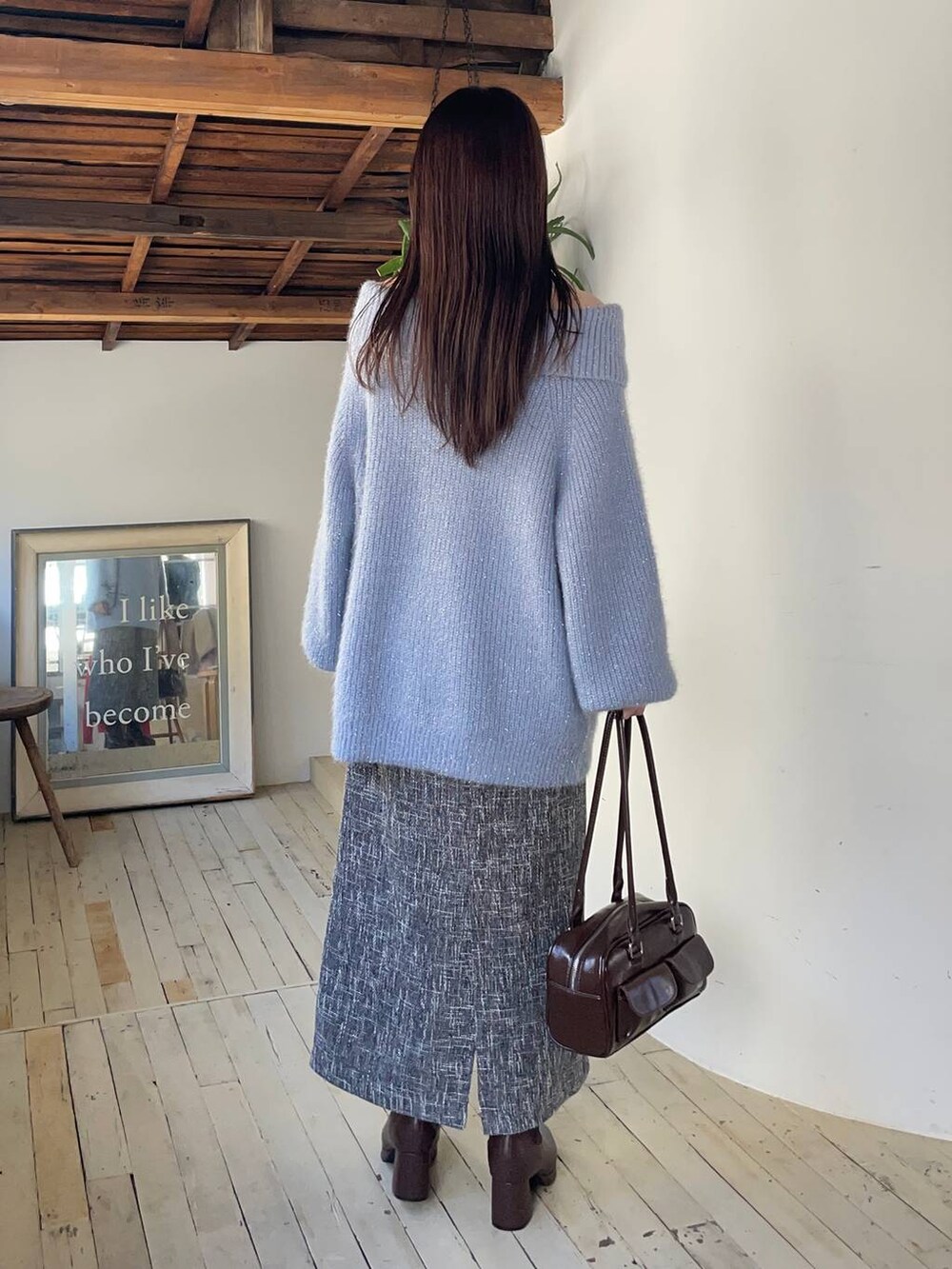 ブラウン系のブーツ、ブラウン系のハンドバッグ、ブラック系のワンピースを着用したレディースの冬コーディネートの2枚目の写真