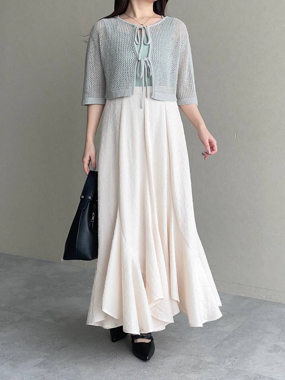 ホワイト系のスカート、グリーン系のカーディガン/ボレロ、ブラック系のショルダーバッグを着用したレディースの春コーディネートの4枚目の写真