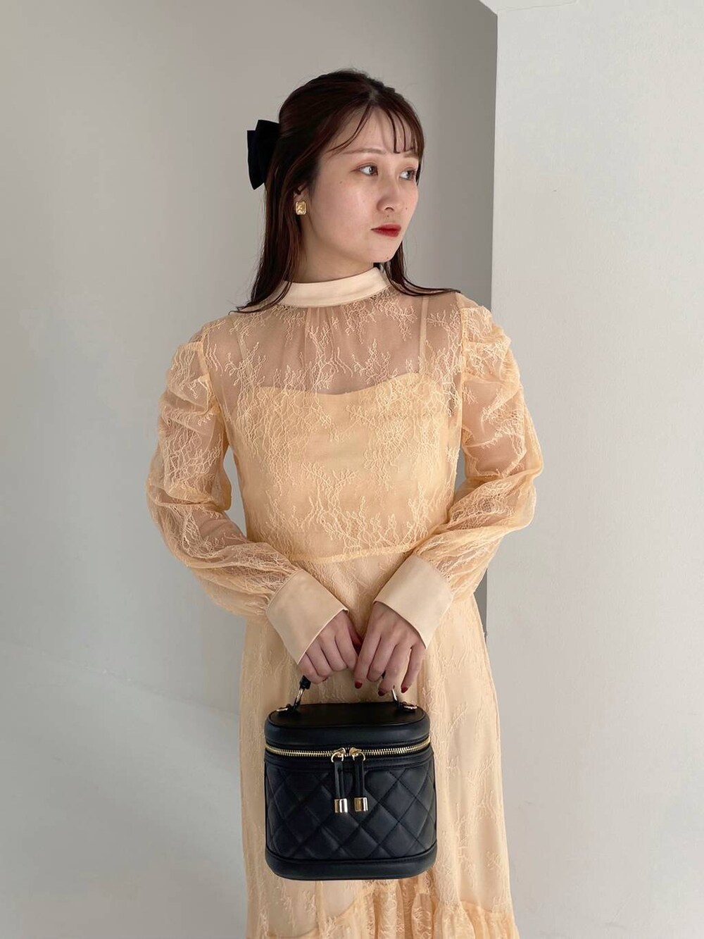 ブラック系のブーツ、ブラック系のショルダーバッグ、オレンジ系のドレスを着用したレディースの秋コーディネートの3枚目の写真