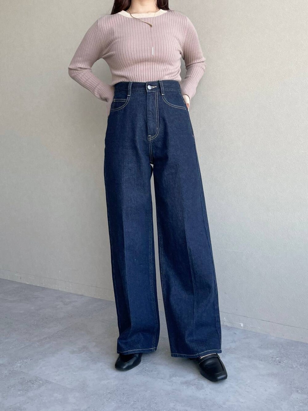 ブラック系のショルダーバッグ、ブルー系のデニムパンツ、ベージュ系のニット/セーターを着用したレディースの冬コーディネートの9枚目の写真