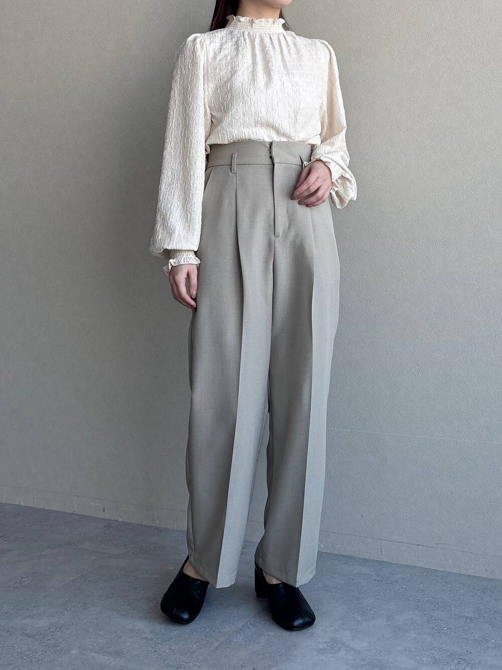 ブラック系のショルダーバッグ、ベージュ系のテーラードジャケット、ベージュ系のスラックスを着用したレディースの冬コーディネートの4枚目の写真