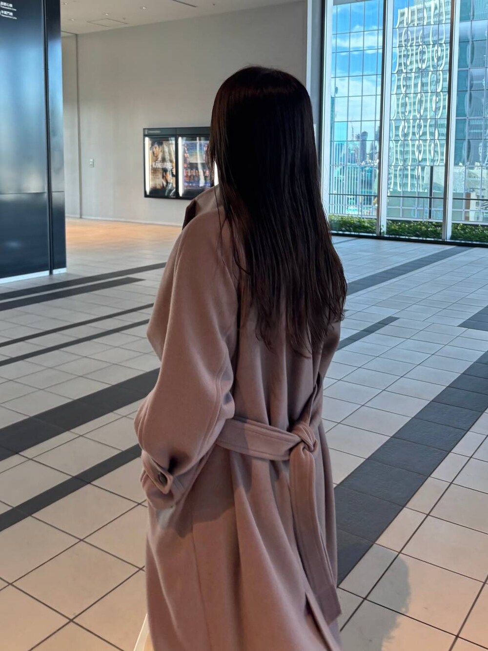 ブラウン系のチェスターコートを着用したレディースの冬コーディネートの3枚目の写真