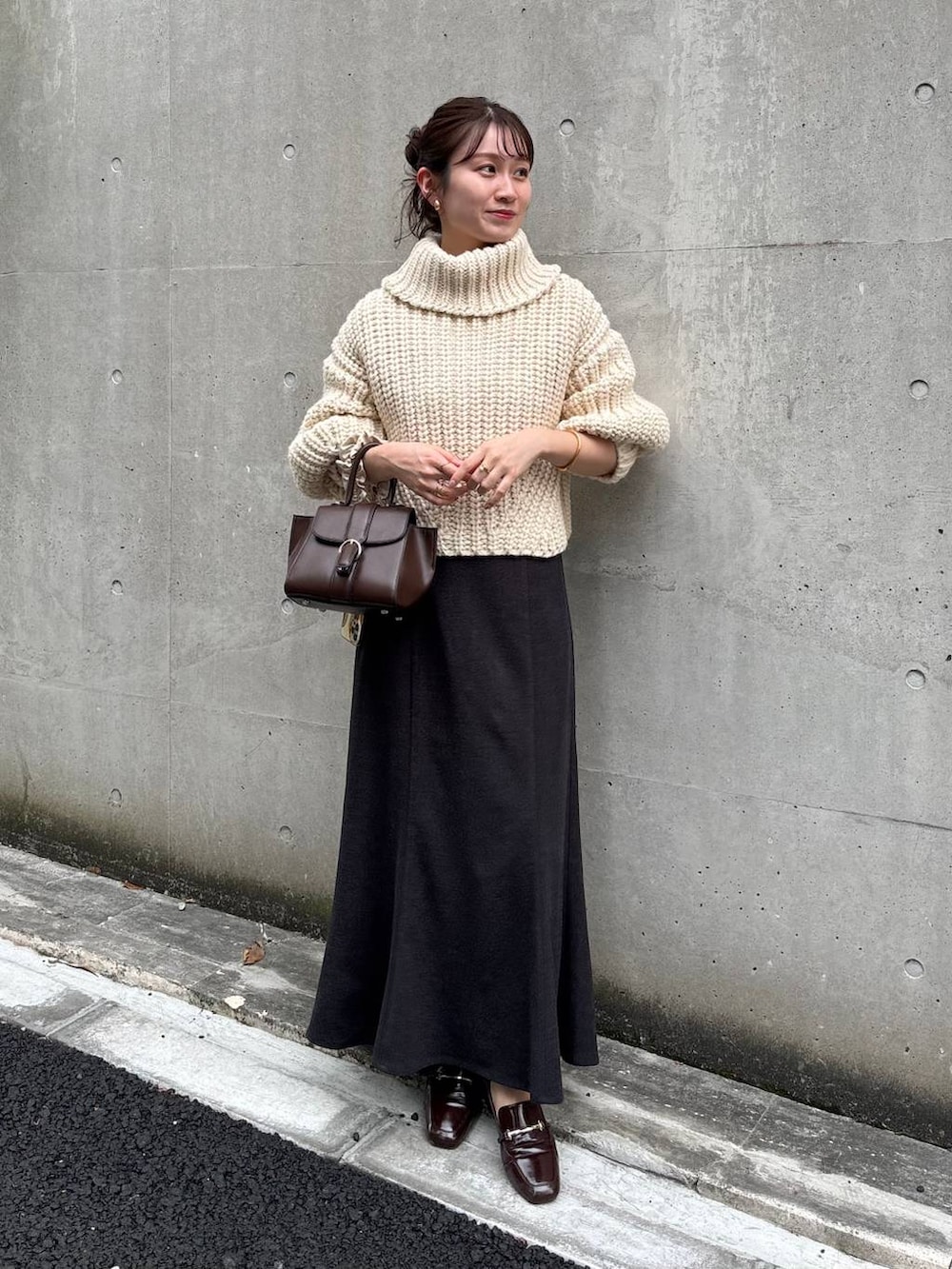 ホワイト系のニット/セーター、グレー系のスカートを着用したレディースの秋コーディネートの2枚目の写真