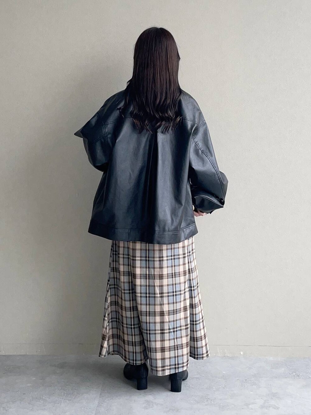 ブラック系のブルゾン、ブラック系のハンドバッグ、ブラック系のブーツを着用したレディースの秋コーディネートの2枚目の写真