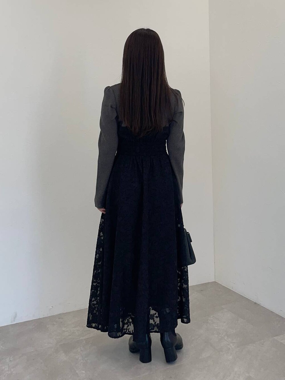 ブラック系のブーツ、ブラック系のショルダーバッグ、ブラック系のワンピースを着用したレディースの冬コーディネートの2枚目の写真