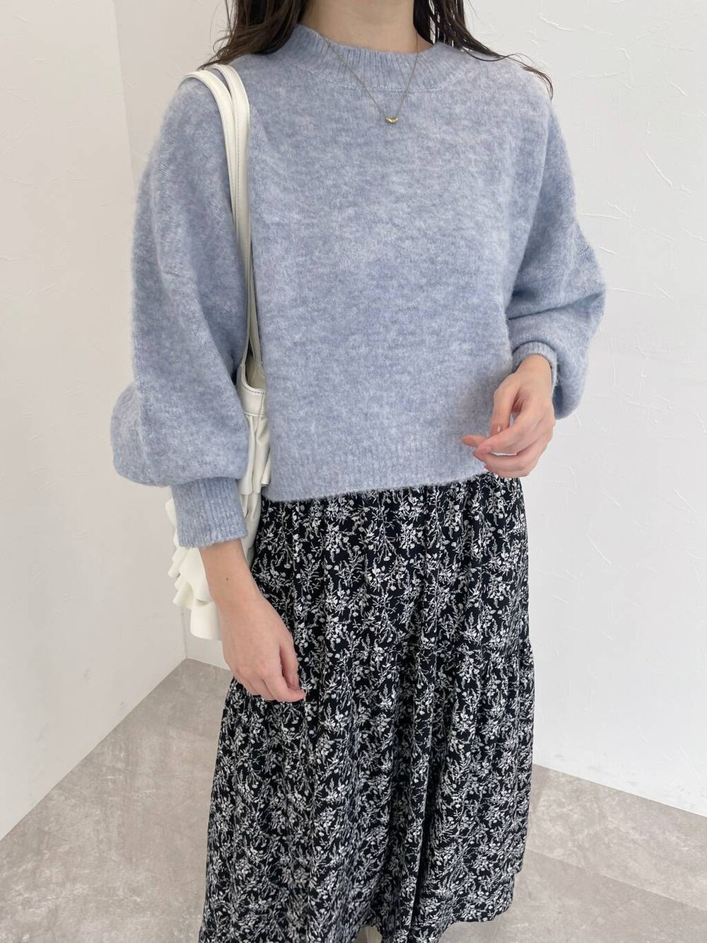 ホワイト系のブーツ、ブルー系のニット/セーター、ブラック系のワンピースを着用したレディースの秋コーディネートの4枚目の写真