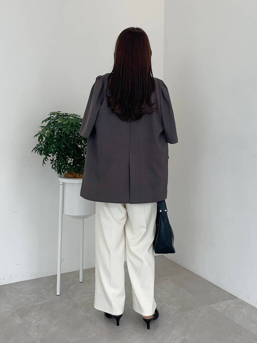 ブラウン系のテーラードジャケット、ブラック系のショルダーバッグ、ブラック系のパンプスを着用したレディースの夏コーディネートの2枚目の写真