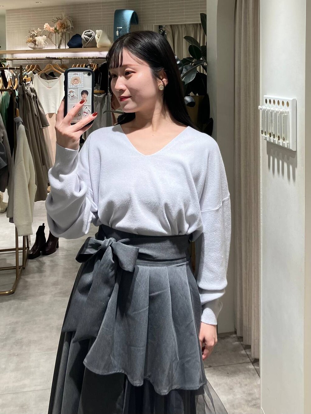 ブラック系のブーツ、グレー系のニット/セーター、グレー系のスカートを着用したレディースの冬コーディネートの2枚目の写真