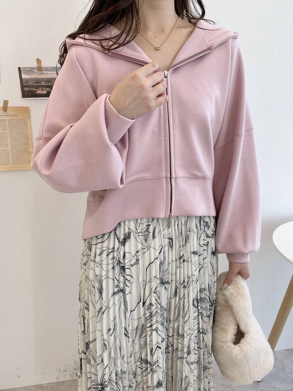 ピンク系のパーカー、ホワイト系のブーツ、ホワイト系のハンドバッグを着用したレディースの冬コーディネートの3枚目の写真