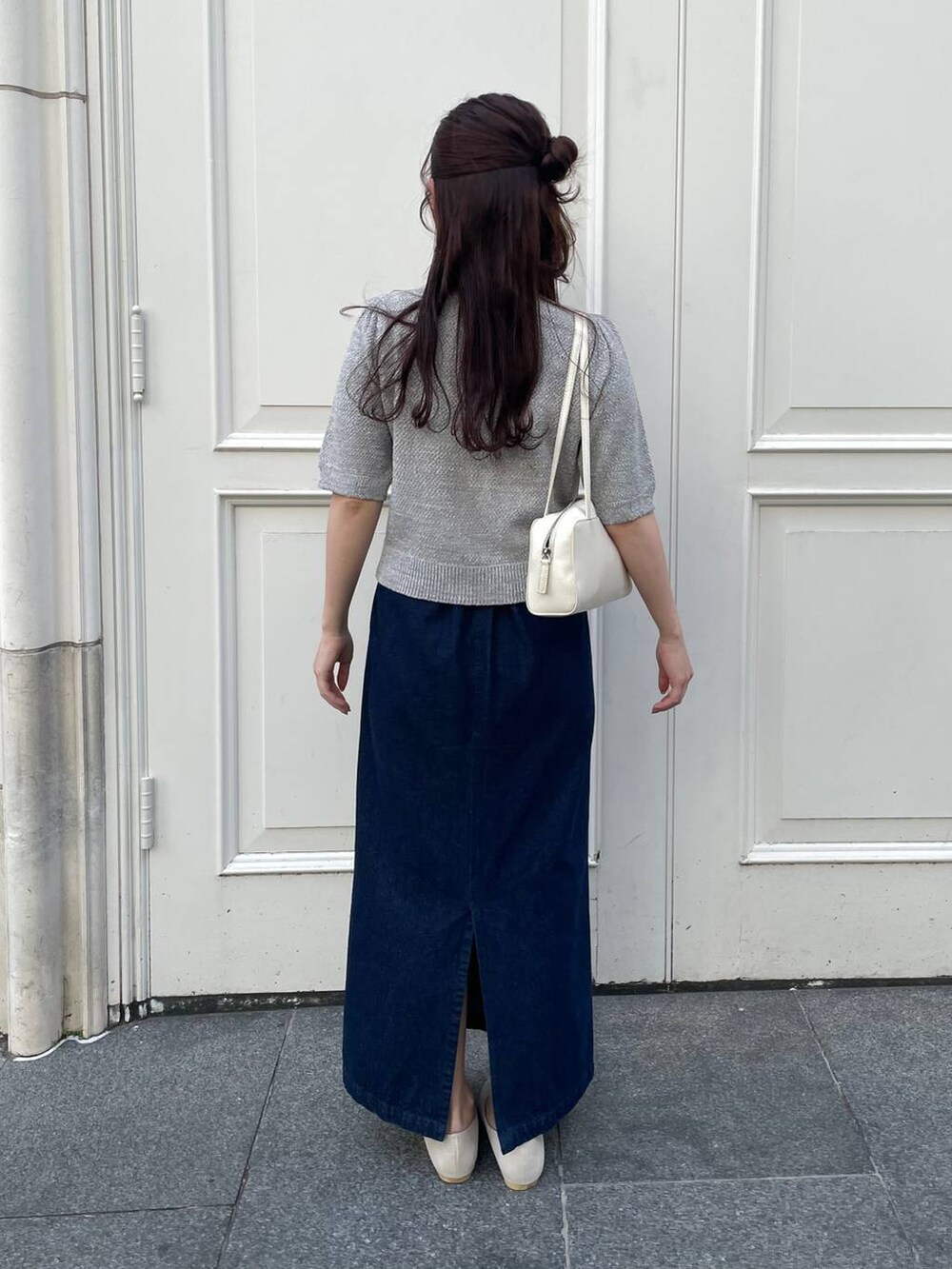 ベージュ系のパンプス、ブルー系のスカート、グレー系のカーディガン/ボレロを着用したレディースの春コーディネートの2枚目の写真