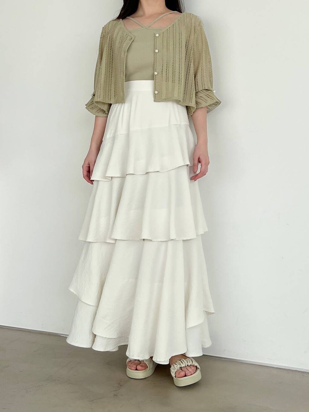 ホワイト系のスカート、ホワイト系のショルダーバッグ、グリーン系のカーディガン/ボレロを着用したレディースの春コーディネートの4枚目の写真