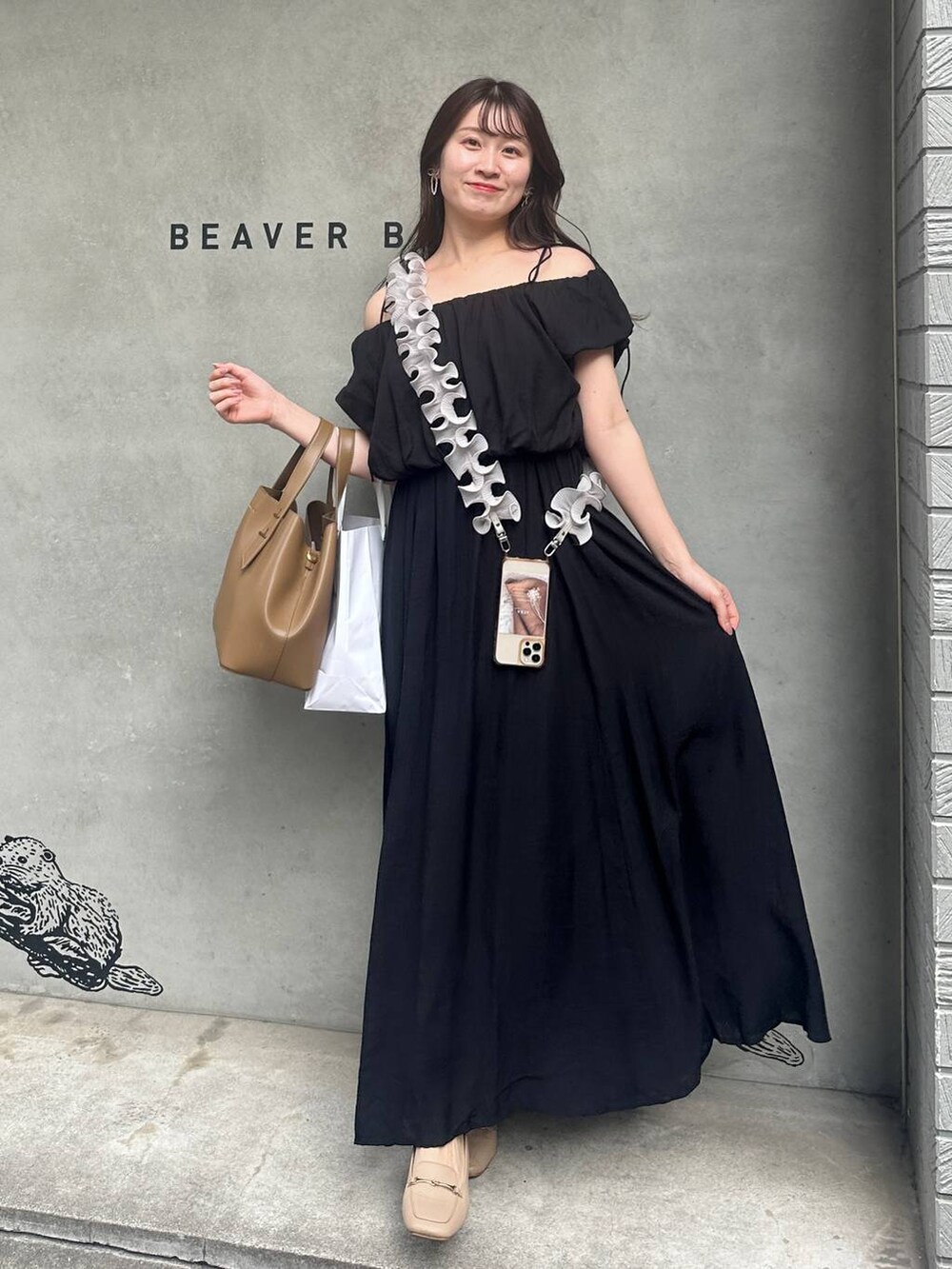 ブラック系のワンピース、グレー系のスマホグッズを着用したレディースの夏コーディネートの3枚目の写真