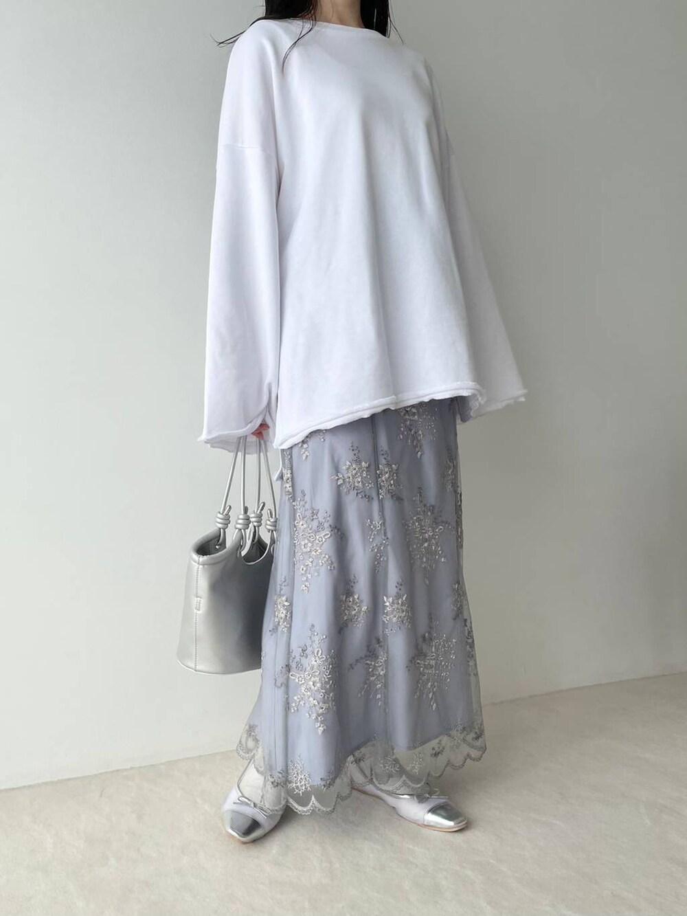 シルバー系のバレエシューズ、ホワイト系のスウェット、ブルー系のスカートを着用したレディースの春コーディネートの5枚目の写真