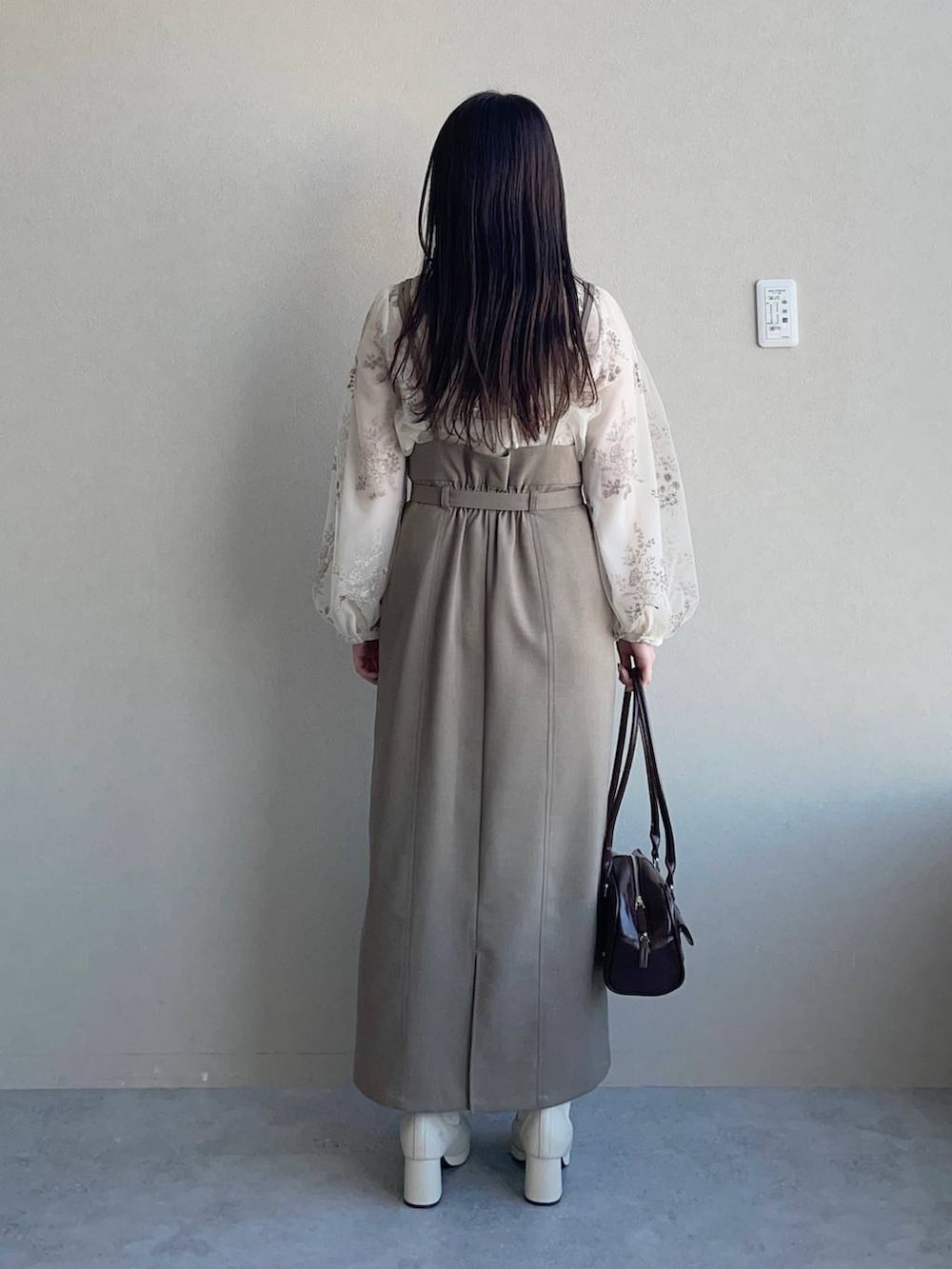 ホワイト系のシャツ/ブラウス、ホワイト系のブーツ、ブラウン系のハンドバッグを着用したレディースの春コーディネートの2枚目の写真