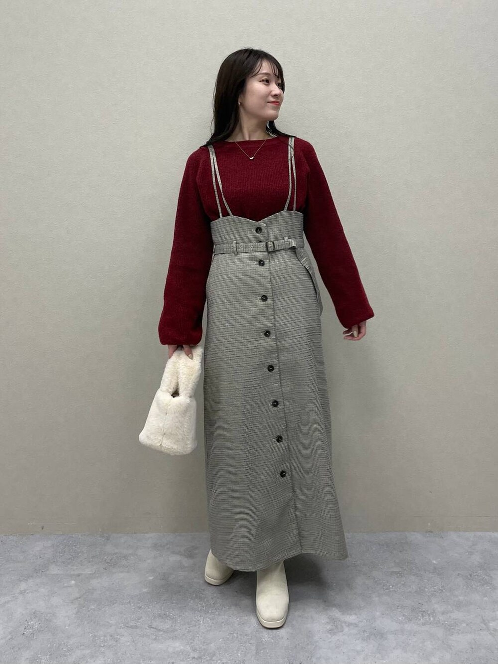 レッド系のニット/セーター、ブラック系のチェスターコート、ホワイト系のブーツを着用したレディースの秋コーディネートの4枚目の写真