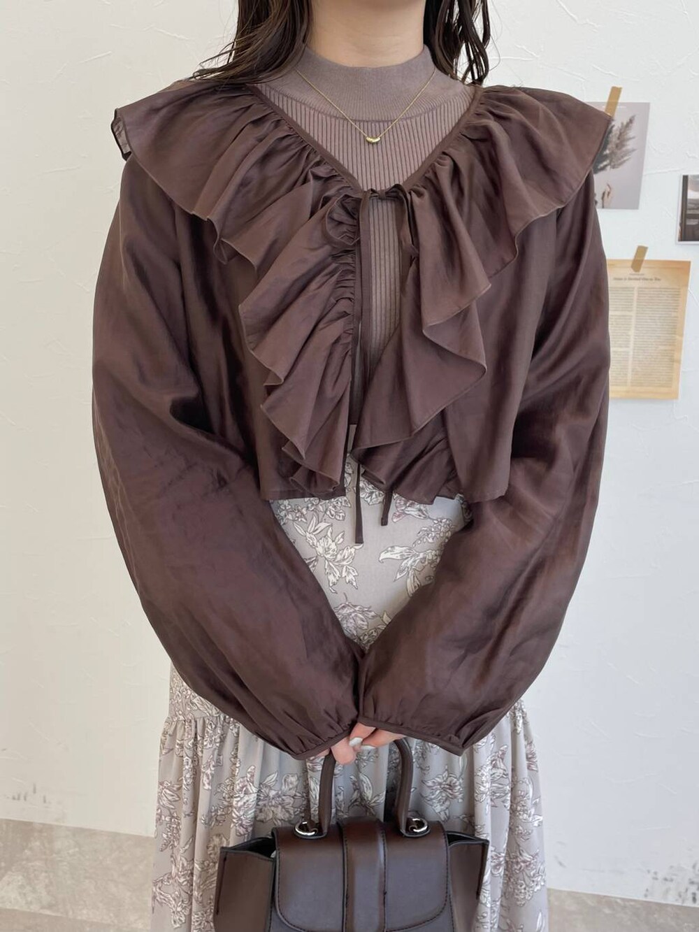 ブラウン系のハンドバッグ、ホワイト系のブーツ、ブラウン系のシャツ/ブラウスを着用したレディースの冬コーディネートの6枚目の写真