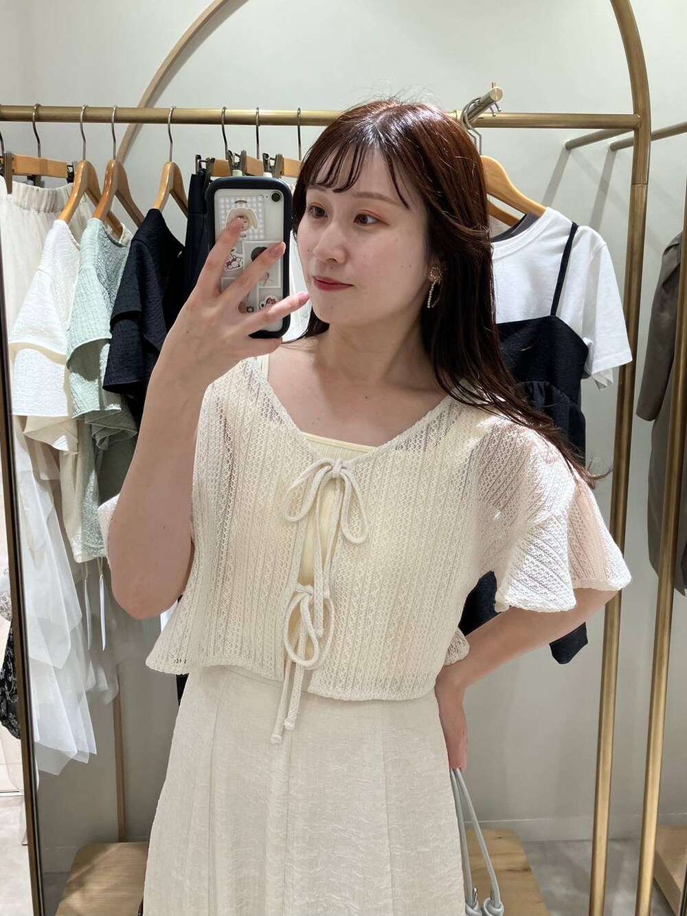 シルバー系のハンドバッグ、ホワイト系のサンダル、ホワイト系のスカートを着用したレディースの春コーディネートの4枚目の写真