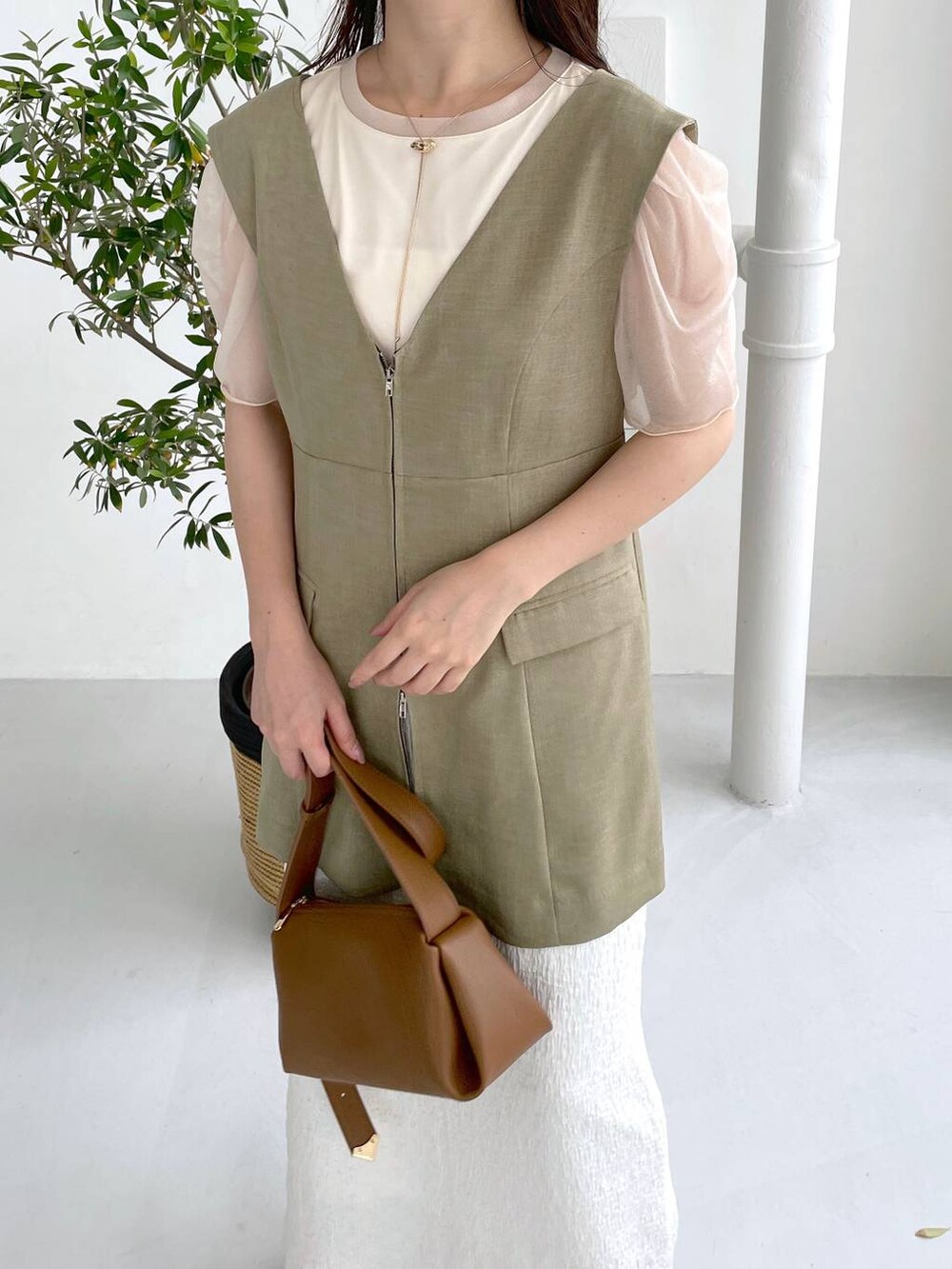 ホワイト系のTシャツ/カットソー、ブラウン系のショルダーバッグ、ホワイト系のスカートを着用したレディースの夏コーディネートの3枚目の写真