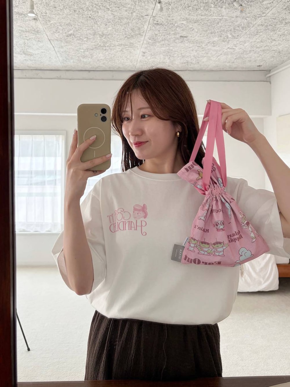 ブラウン系のスカート、ホワイト系のTシャツ/カットソー、ホワイト系のサンダルを着用したレディースの夏コーディネートの4枚目の写真