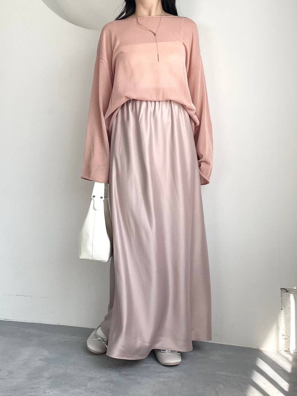 ピンク系のニット/セーター、シルバー系のバレエシューズ、ホワイト系のキャミソールを着用したレディースの春コーディネートの4枚目の写真