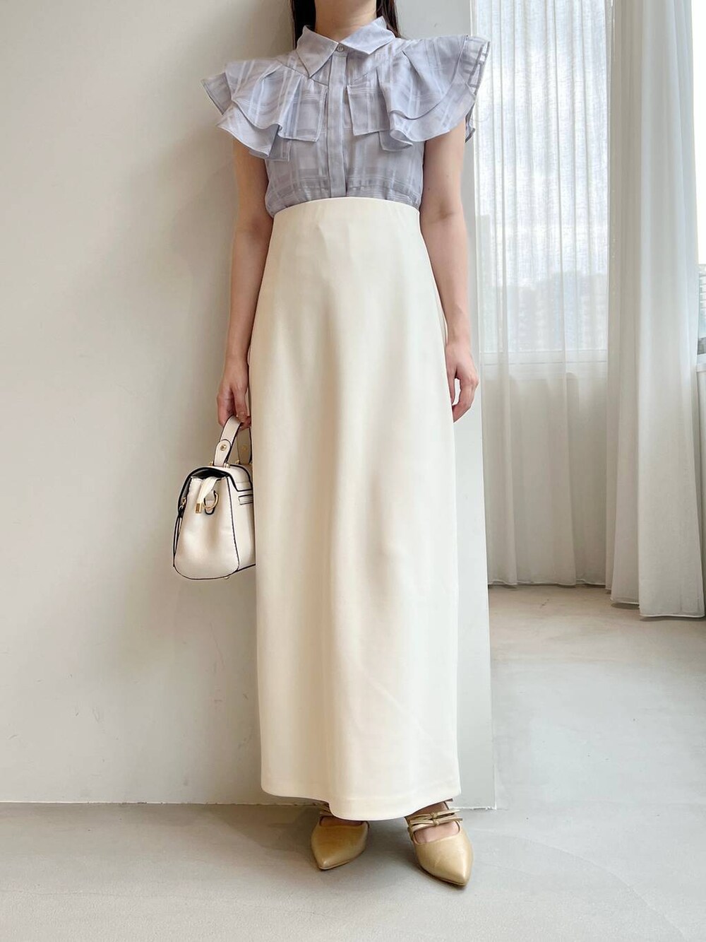 ゴールド系のパンプス、ホワイト系のショルダーバッグ、ブルー系のシャツ/ブラウスを着用したレディースの夏コーディネートの3枚目の写真