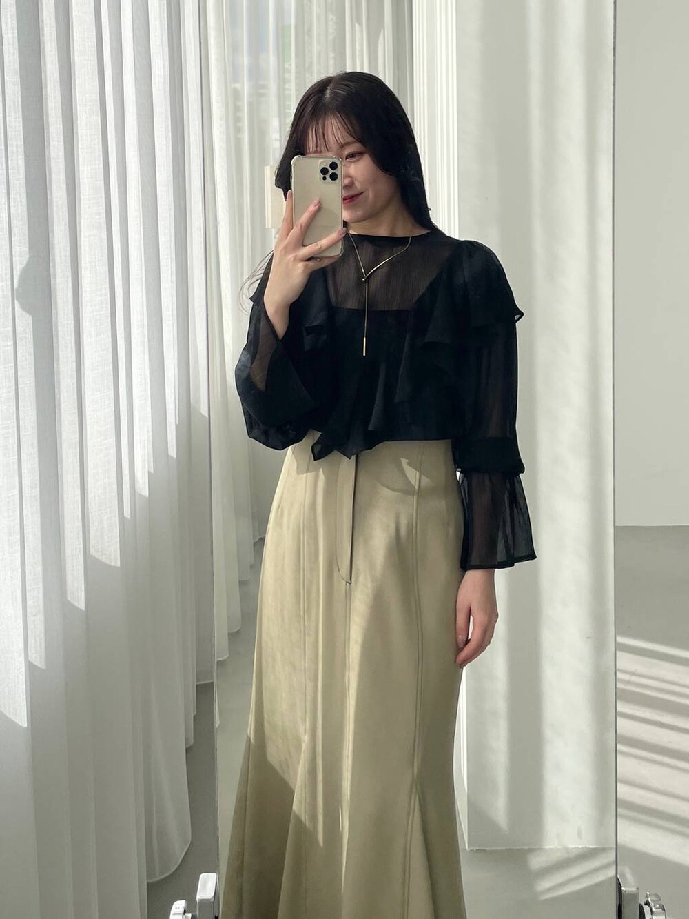 ブラック系のショルダーバッグ、ブラック系のパンプス、ベージュ系のスカートを着用したレディースの春コーディネートの5枚目の写真