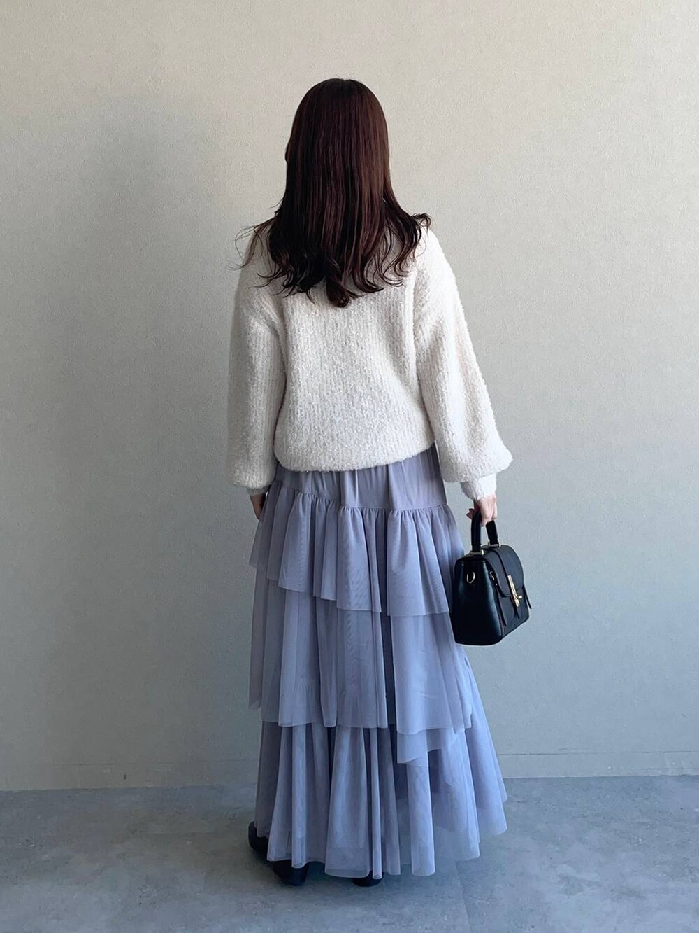 ブラック系のローファー、ブラック系のショルダーバッグ、ホワイト系のニット/セーターを着用したレディースの冬コーディネートの2枚目の写真