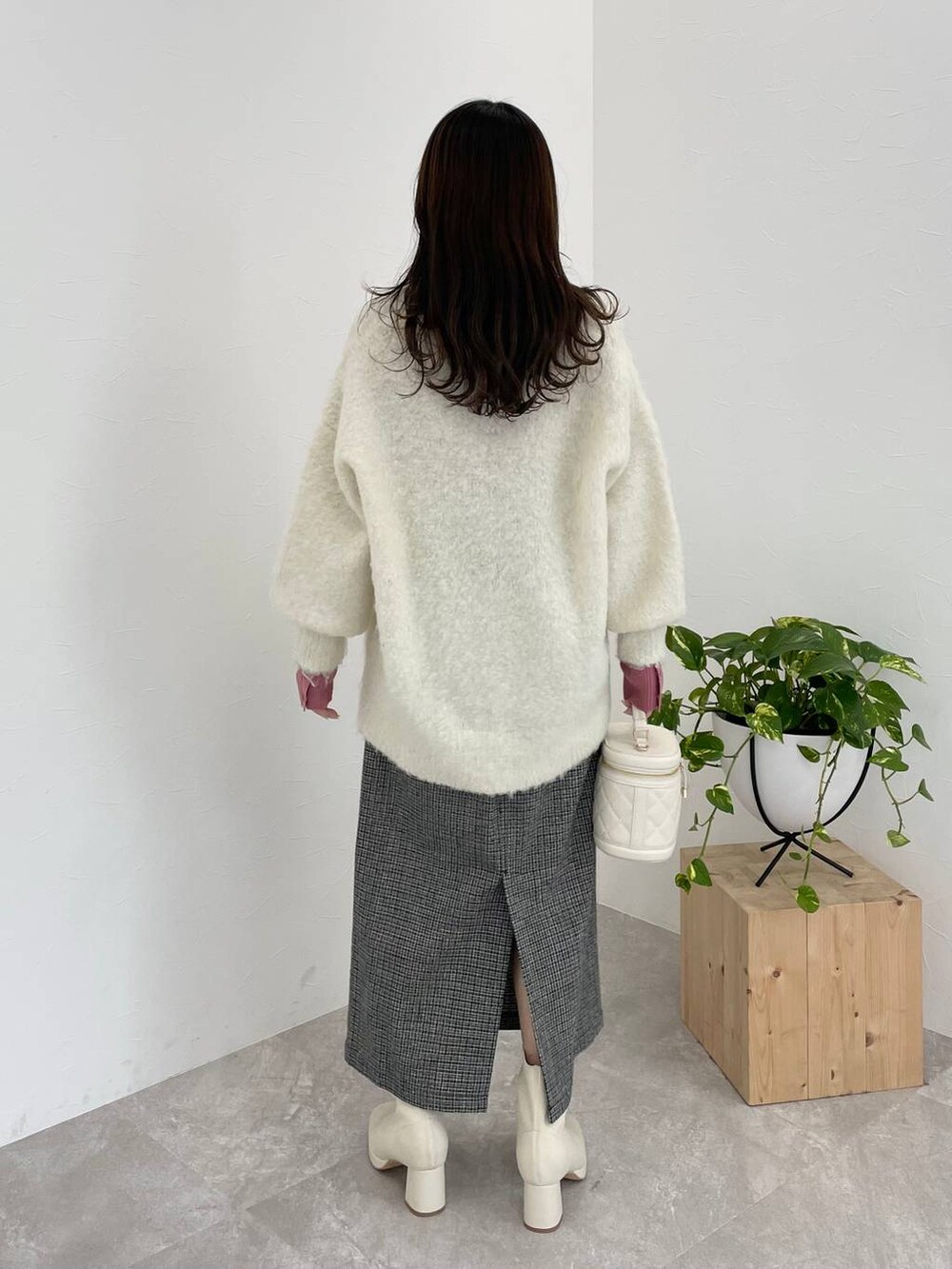 ホワイト系のブーツ、ピンク系のニット/セーター、ホワイト系のカーディガン/ボレロを着用したレディースの冬コーディネートの2枚目の写真