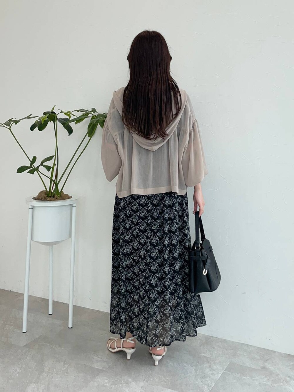 ブラック系のワンピース、ブラック系のショルダーバッグ、ベージュ系のパーカーを着用したレディースの夏コーディネートの2枚目の写真