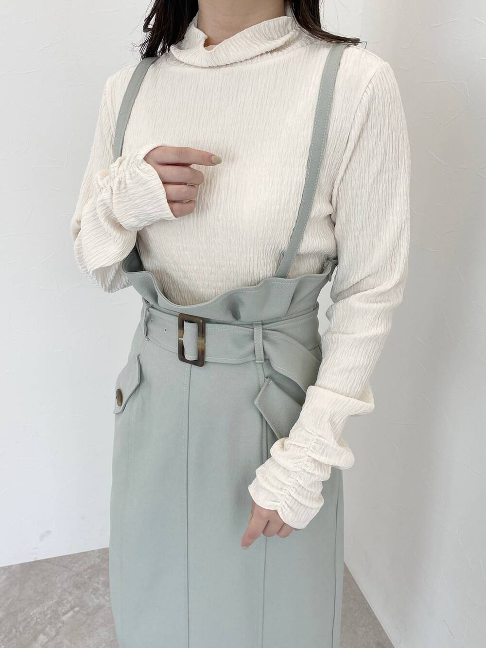 ホワイト系のブーツ、ホワイト系のハンドバッグ、ホワイト系のチェスターコートを着用したレディースの冬コーディネートの6枚目の写真