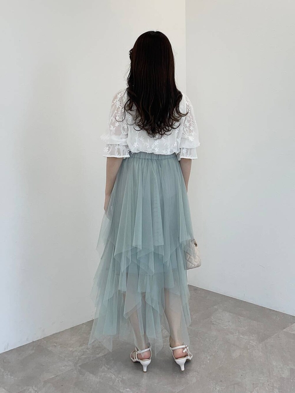 ホワイト系のシャツ/ブラウス、ホワイト系のショルダーバッグ、ホワイト系のタンクトップを着用したレディースの春コーディネートの2枚目の写真